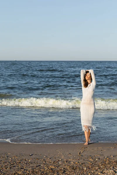 Donna scalza che cammina sulla sabbia bagnata vicino al mare sulla spiaggia — Foto stock