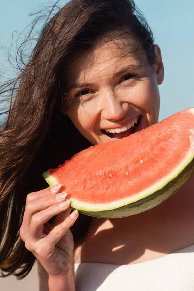 Felice giovane donna mangiare affettato e succosa anguria in estate — Foto stock