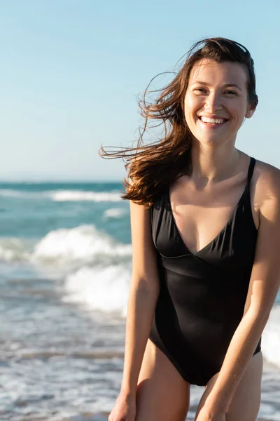 Retrato de mulher feliz em roupa de banho preta perto do mar — Fotografia de Stock