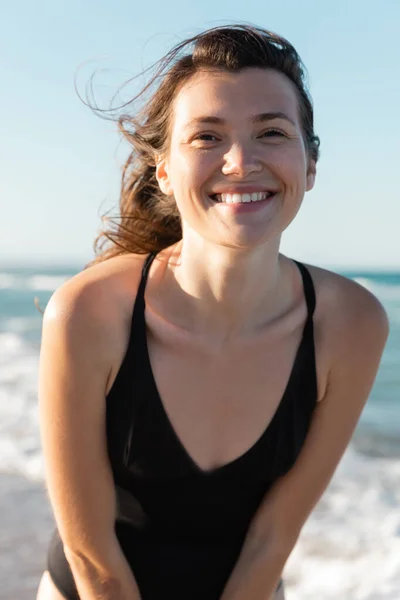 Portrait of happy woman in black swimwear looking at camera — Stock Photo