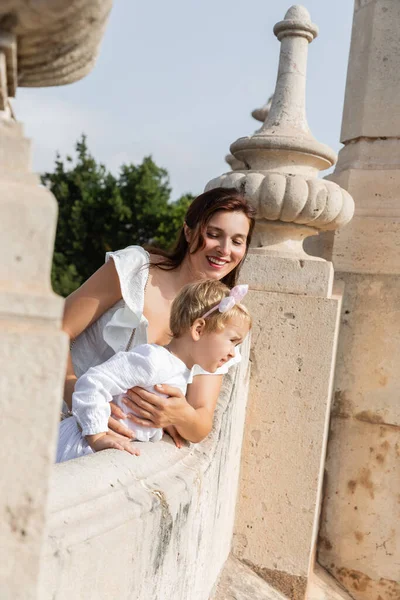 Mother and toddler daughter standing on stone Puente Del Mar bridge in Valencia — Stockfoto