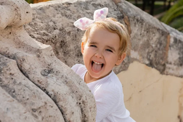 Toddler child sticking out tongue near stone Puente Del Mar bridge in Valencia — Photo de stock