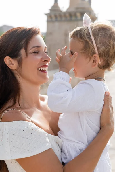 Mother embracing toddler daughter outdoors in Valencia — Photo de stock