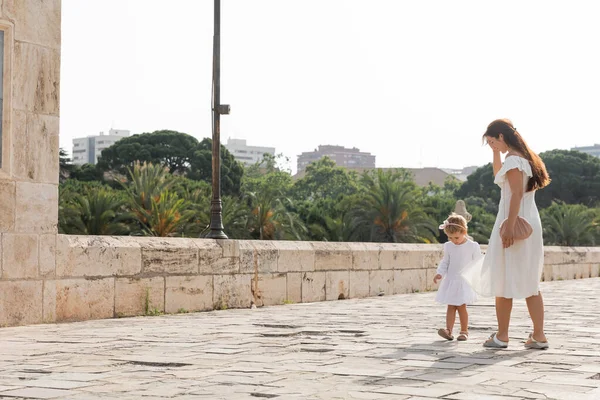 Toddler girl in summer dress walking near mom on Puente Del Mar bridge in Valencia — Fotografia de Stock