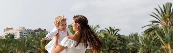 Brunette woman playing with cheerful daughter in Valencia, banner — Stock Photo