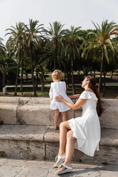 Frau im Sommerkleid berührt Baby auf Brücke Puente del Mar in Valencia — Stockfoto