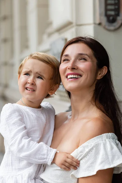 Positive woman holding daughter and looking away outdoors in Valencia — Stock Photo