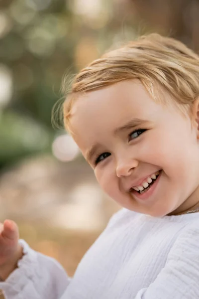 Portrait of smiling toddler child looking at camera outdoors — Stock Photo