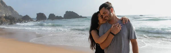Smiling woman hugging happy boyfriend near ocean in portugal, banner — Stock Photo