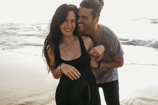 Fröhlicher Mann kitzelt freudige Freundin im Kleid nahe Ozean in Portugal — Stockfoto