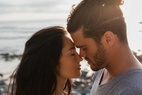 Vue latérale de l'homme et de la femme avec les yeux fermés sur la plage en portugais — Photo de stock