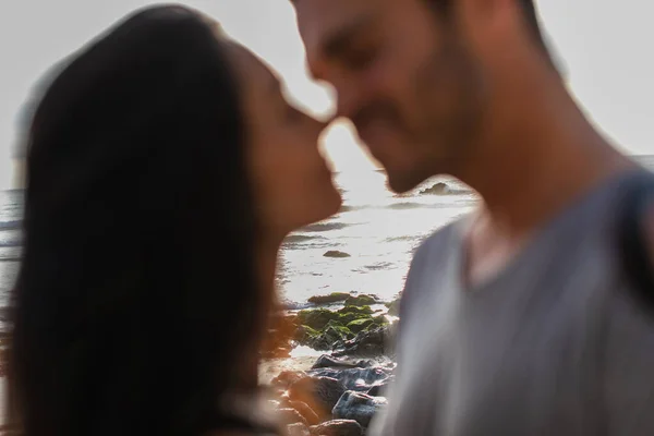 Plage rocheuse avec des pierres près de l'océan et couple flou au premier plan — Stock Photo