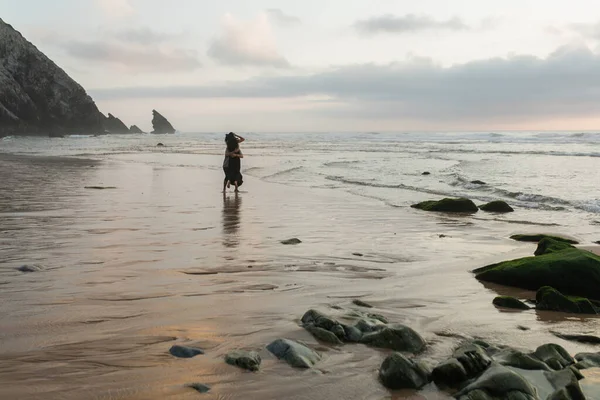 Vue arrière de l'homme et de la femme étreignant tout en se tenant dans l'eau de l'océan — Photo de stock