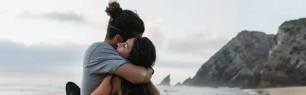 Uomo e bruna donna con gli occhi chiusi che si abbracciano sulla spiaggia in portoghese, banner — Foto stock