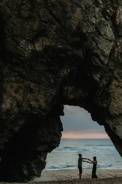 Seitenansicht eines glücklichen Paares, das bei Sonnenuntergang am Strand tanzt — Stockfoto