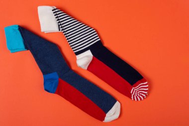 iki çift renkli çorap, turuncu arka planda, yaşam tarzı konsepti, kopyalama alanı
