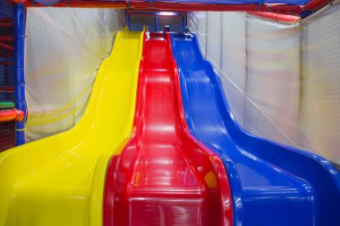 Çocukların oyun kompleksinde üç renkli plastik slayt, aşağı kayma, çocuklar için eğlence, konsept
