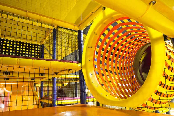 yellow labyrinth with a large pipe in the children's play complex, entertainment for children, concept