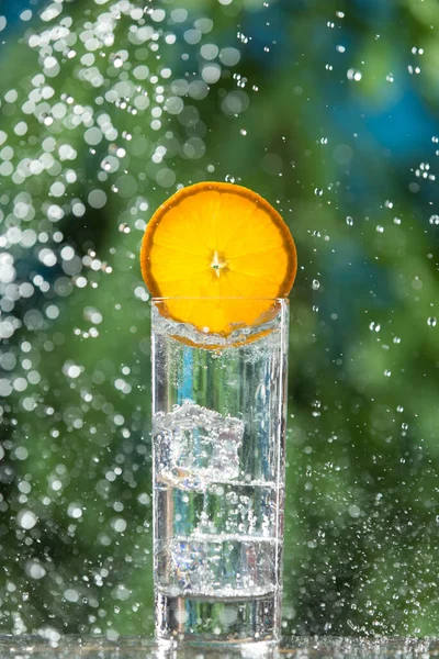 氷と輝く水とオレンジのスライスをガラスに囲まれた水と概念とクローズアップ — ストック写真