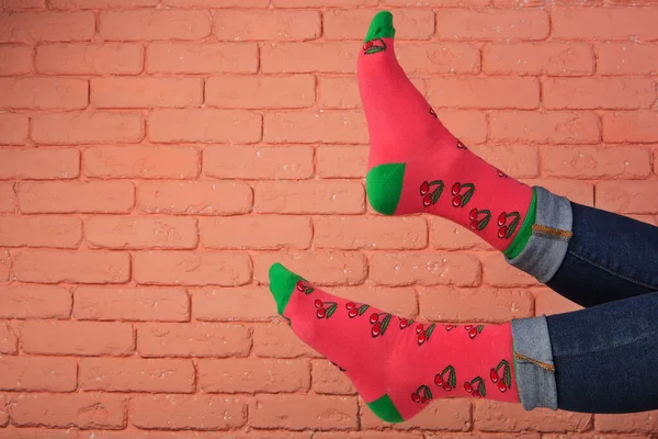 Жіночі Ноги Червоних Шкарпетках Візерунком Ягід Вишні Фоні Цегляної Стіни — стокове фото