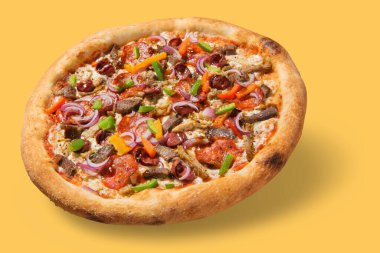 İtalyan pizzası ördek etiyle, salamlı ve sebzeli, havada asılı, sarı arka planda bir gölge, yiyecek konsepti