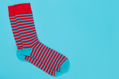 Kırmızı ve turkuaz çizgili bir çift çorap, turkuaz arka plan, konsept, kopyalama alanı