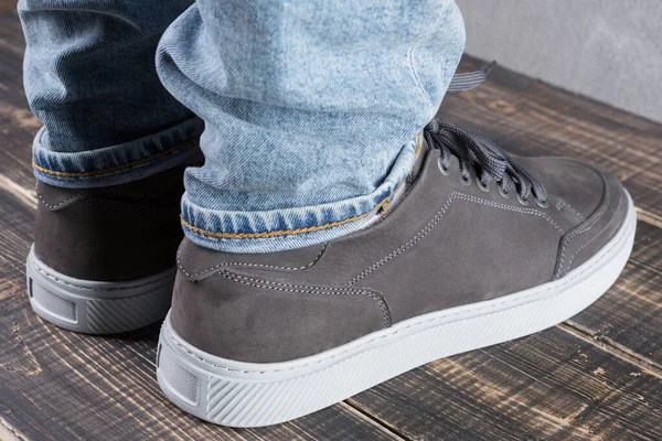 Gri deri ayakkabılı erkek bacakları, tahta tahtalar, arka taraf, konsept, yakın çekim.