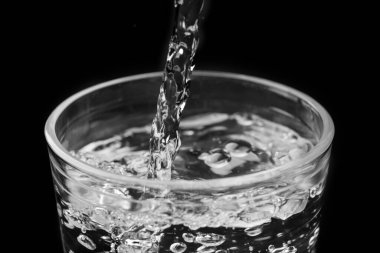 Camdan bir suda, siyah bir zeminde, makro fotoğrafçılık.