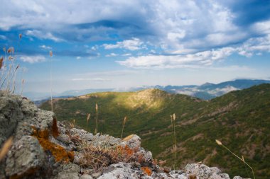 Gökyüzünde güzel bulutlar olan dağ manzarası, seçici odaklanma, güneş ışınları.