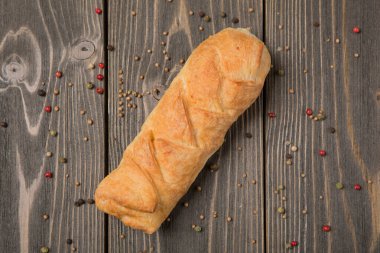 İçi doldurulmuş puf böreğinden bir ürün, ahşap bir masada çeşitli dolgu malzemesi, baharat serpiştirme...