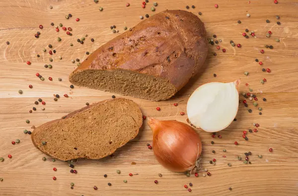 木のテーブルの上のパンと玉ねぎの切り身素朴なスタイルトップビュー — ストック写真
