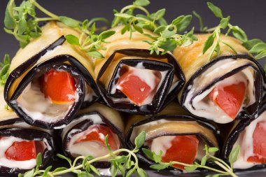 Sarımsak soslu ve domatesli patlıcan ruloları, yakın plan.