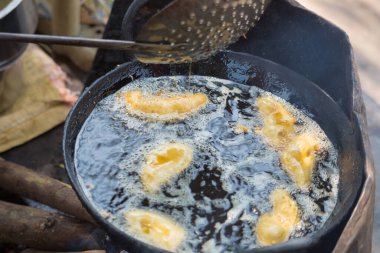 Geleneksel Hint sokak yemekleri tereyağı ve muz dolu bir kazanda kızartılır.