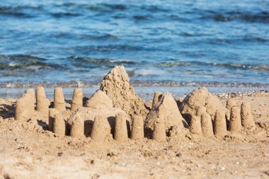 Kumsaldaki kumdan kale mavi denize karşı, çocukların yaratıcılığı, dinlenme ya da tatil kavramı