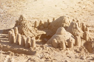 Kumsaldaki kumdan kale ve güneş ışınları, çocukların yaratıcılığı, tatil ya da tatil kavramı