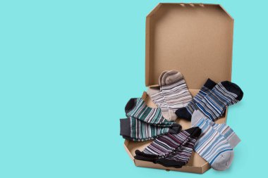 Pizza kutusunda, çizgili çorap çeşitleri pizza, konsept, turkuaz arka plan, fotokopi alanı gibi daireler çiziyor.