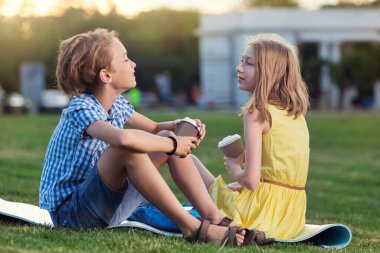 Erkek ve kız, bir randevuda, dışarıda dinlenirler, kahve içerler ve sohbet ederler, yaşam tarzı