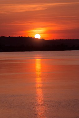 portakal rengi gün batımı, güneş kıyıya değdi, güneşin sudaki yansıması, bol su, doğa kavramı.