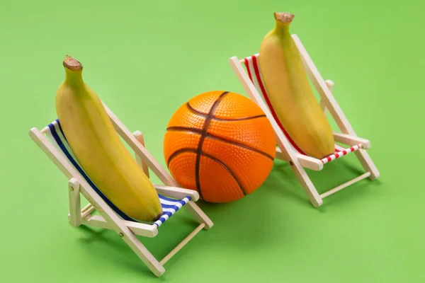 Két Napozóágy Egy Kosárlabda Között Zöld Háttér Napozóágyak Két Banán — Stock Fotó
