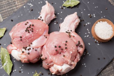 İki hindi omzu, kanadın üst kısmı, çiğ et, siyah tahtada, tuz ve baharat.