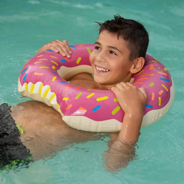 Счастливый Мальчик Плавает Воде Надувным Кольцом Который Выглядит Пончик Летние — стоковое фото