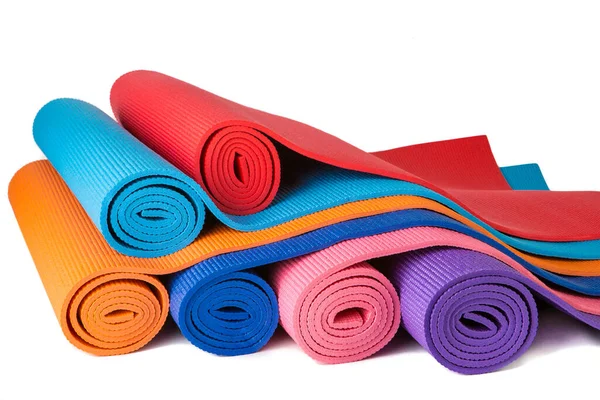 Yatay olarak beyaz arka planda, yoga ve aktif yaşam tarzı için yakın plan izole edilmiş çeşitli renkli halılar.