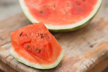 Eski bir tabureye, kesilmiş bir karpuza, bir karpuz zeminine ve bir dilime, bir kırmızı hamura, bir yakın plan.