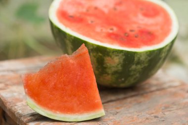 Eski bir tabureye, kesilmiş bir karpuza, bir karpuz zeminine ve bir dilime, bir kırmızı hamura, bir yakın plan.