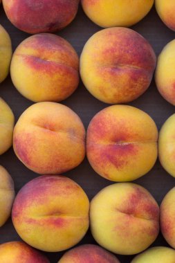 Olgun şeftaliler sırayla bir kutuda yatıyor, ayrıntılarıyla, yeni bir mahsul.