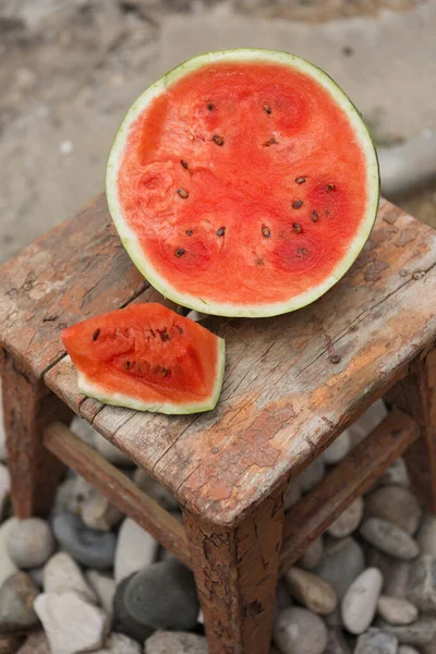 on an old stool a cut watermelon, a floor of a water-melon and a slice, a red pulp, a close-up