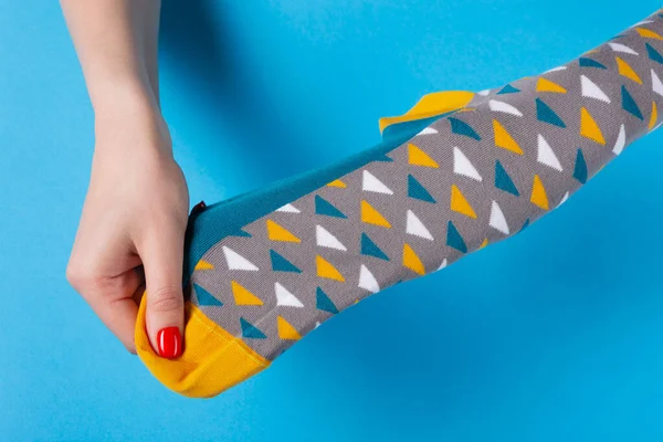 Жіночі Руки Тримають Кольорові Шкарпетки Розтягують Демонструють Концепцію Синьому Фоні — стокове фото