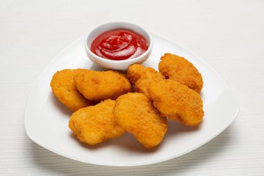 golden pieces of deep-fried cheese laid out on a white plate, next to a red sauce in a bowl, fast food