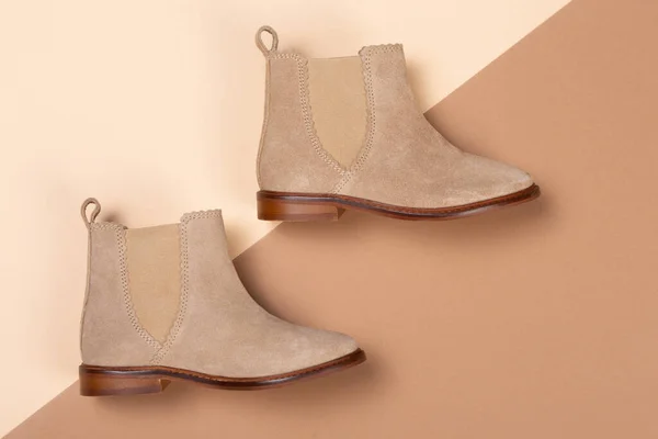 autumn women's beige boots on a beige and brown background, shopping concept