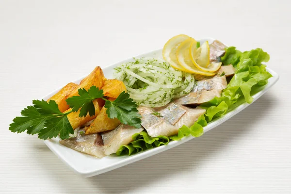 Herring Lined Slices Plate Fried Potatoes Raw Onions Decorated Greens — Zdjęcie stockowe